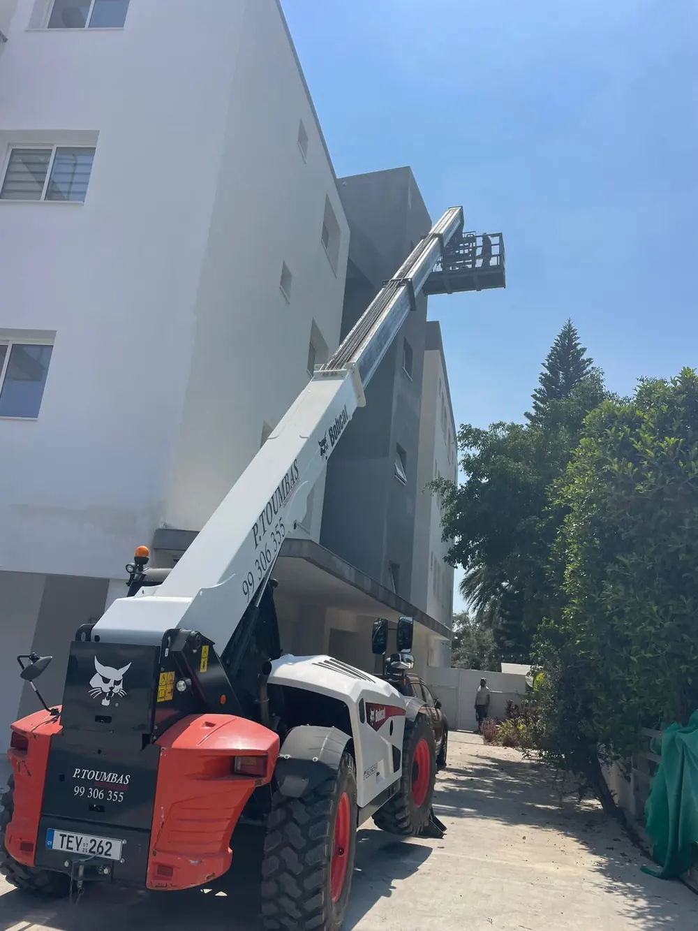 Telescopic forklift lifting materials to a high-rise building in Limassol
